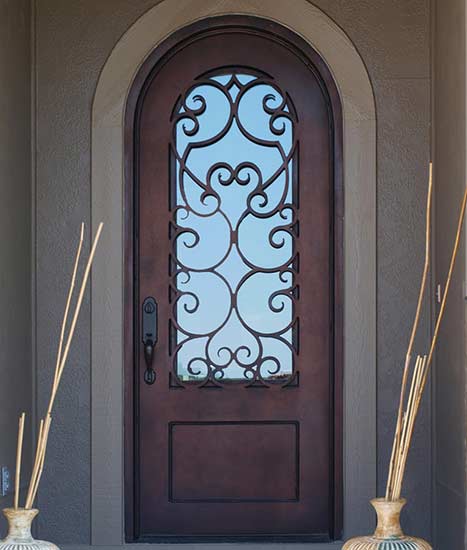 Custom single round top iron door entry, Tudor style, Patented Thermal Break, red copper finish, clear glass